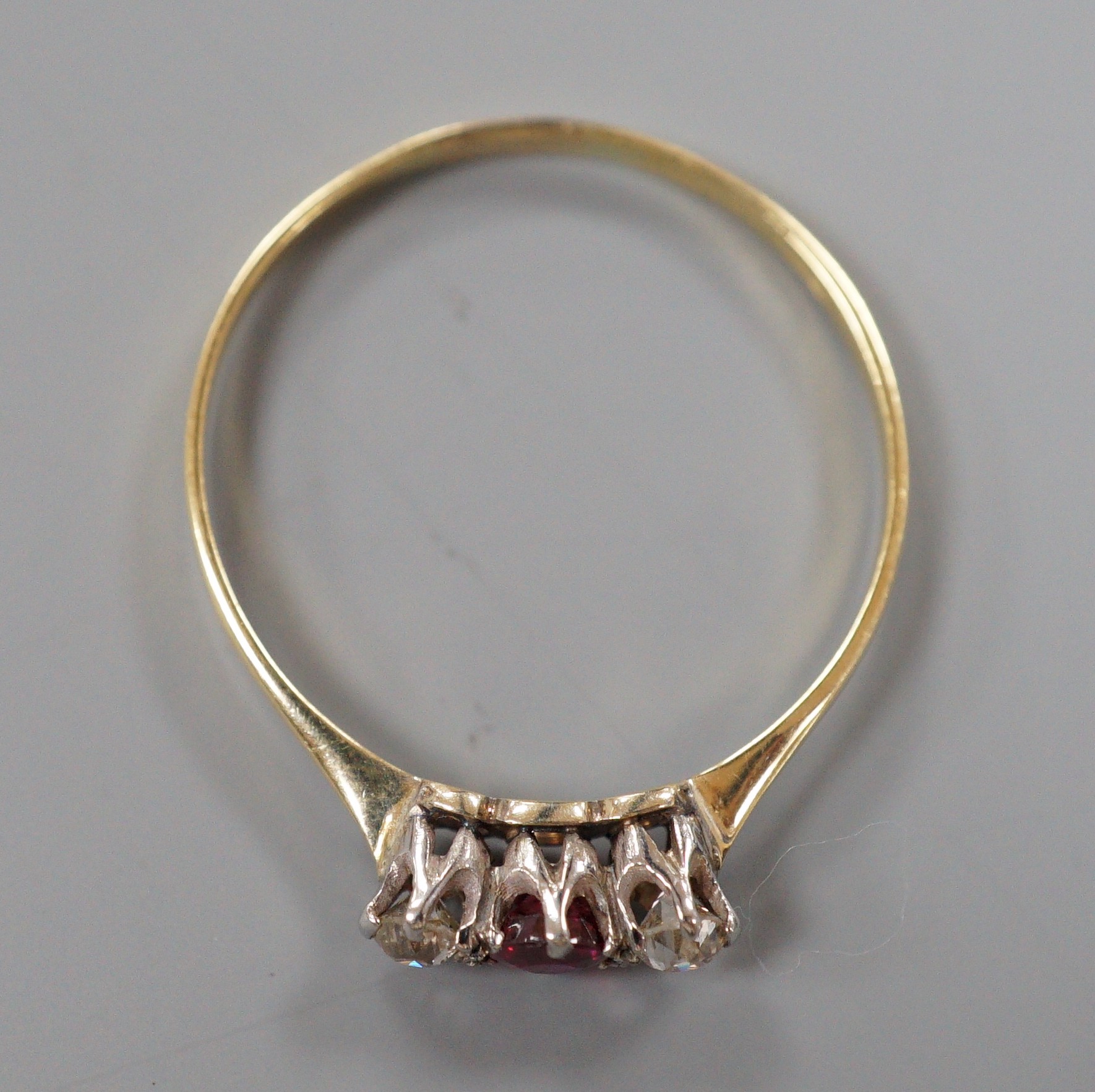 An 18ct, ruby and diamond set three stone ring, size V, gross weight 1.7 grams.